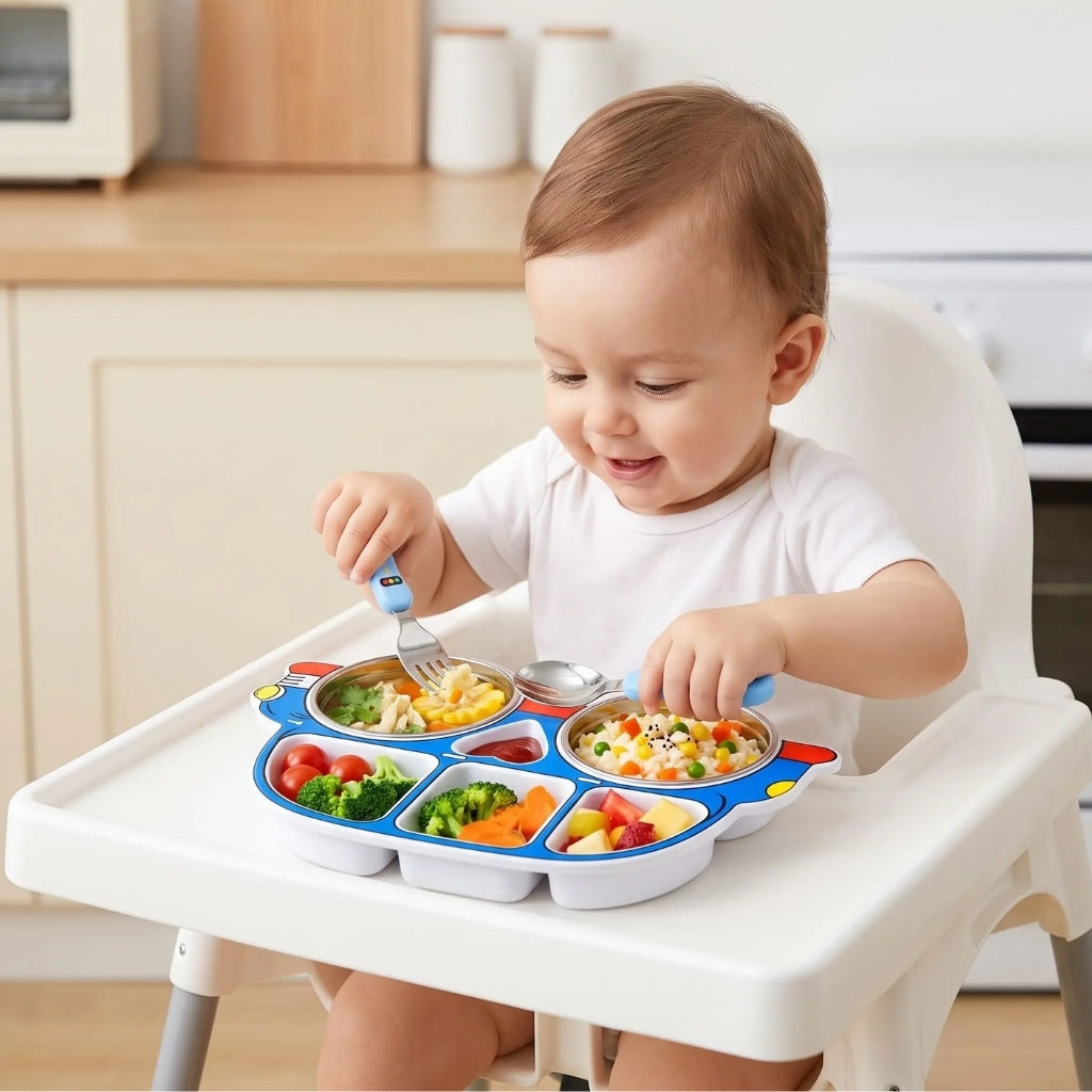 Bébé dans sa chaise haute qui mange seul avec sa fourchette dans son assiette enfant en inox voiture bleue