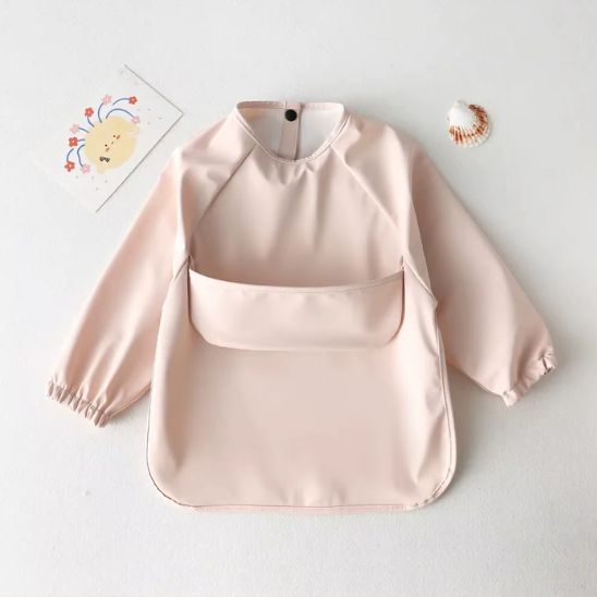 Bavoir bébé manche longue couleur unie porté par enfant pendant le repas