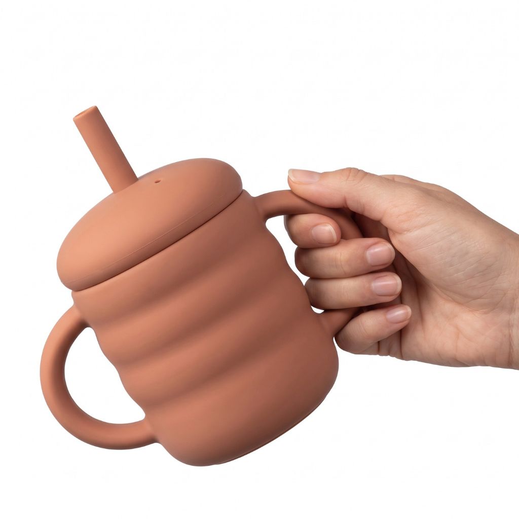 Tasse d'apprentissage bébé inclinée pour montrer le système anti-fuite